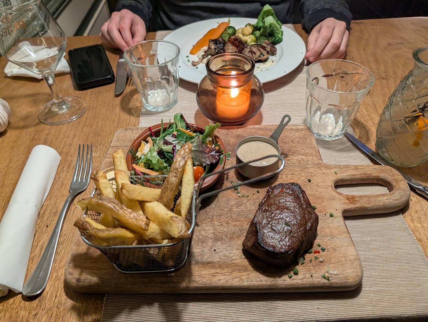 Steak met frites en salade op een houten plank