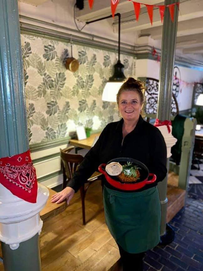 Een van de gastvrouwen van De Gaanderij serveert een gerecht in het restaurant